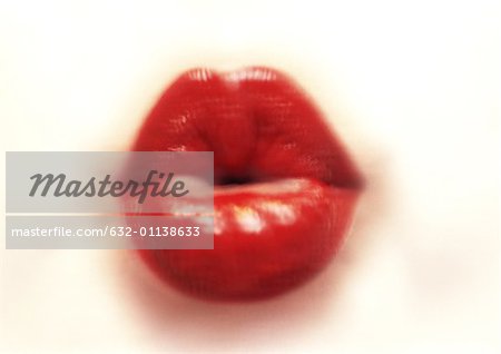 Woman's mouth with red lipstick purckering, blurred, close-up