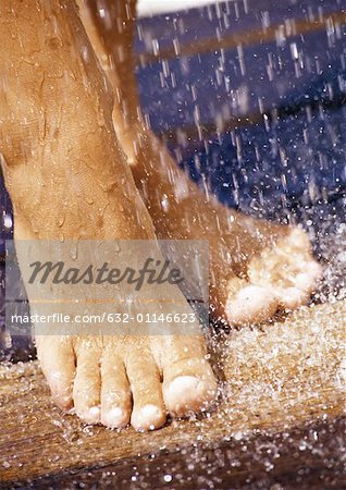 Feet under shower, close-up