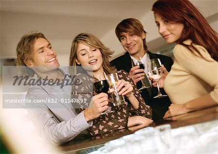 Young men and women drinking at bar