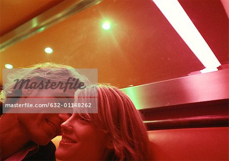 Man leaning to kiss woman's cheek