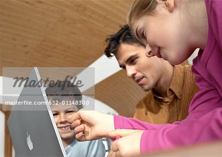 Father, son and daughter looking at laptop computer together.