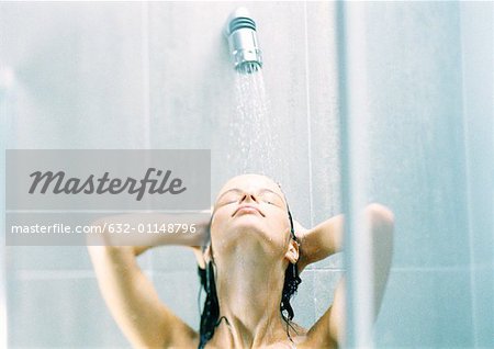 Woman taking shower, head back, close-up.