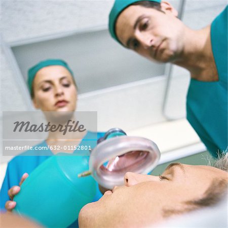 Doctors placing oxygen mask over patient's face
