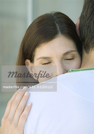 Woman with head on man's shoulder, closed eyes, partial view