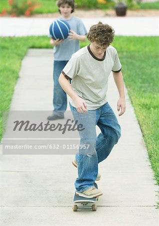 Boy skating on suburban sidewalk