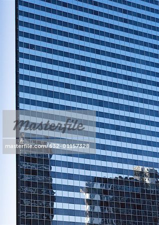 Skycraper, full frame close-up view with reflection of other buildings on facade