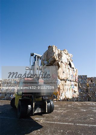 Forklift carrying bales of used paper
