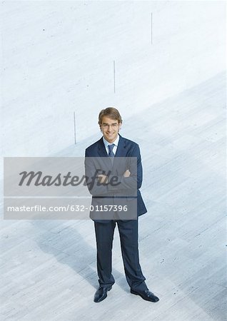 Businessman standing with arms folded, high angle view