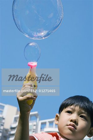 Boy making bubbles with bubble gun