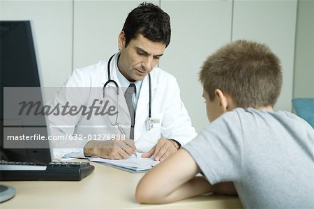 Doctor sitting across from child patient, taking notes