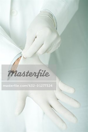 Doctor putting on latex gloves