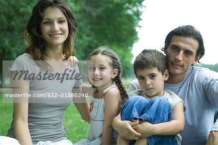 Family outdoors, smiling at camera, portrait