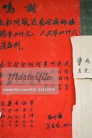 Handwritten chinese characters on ad posted on wall, close-up