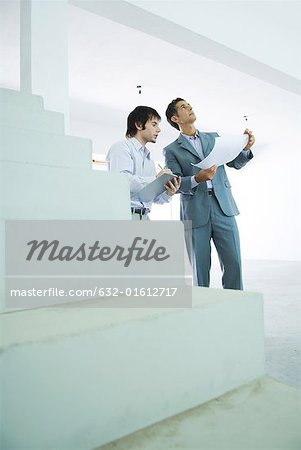 Two well-dressed men inspecting home interior