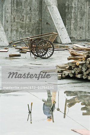 Construction worker at construction site, reflected in puddle of water