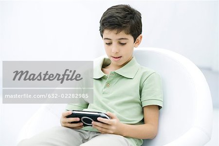 Boy playing handheld video game