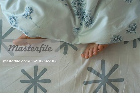 Woman's feet sticking out from under duvet