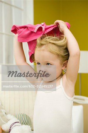 Little girl holding shirt over her head