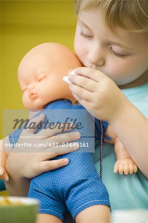 Little girl holding baby doll, close-up