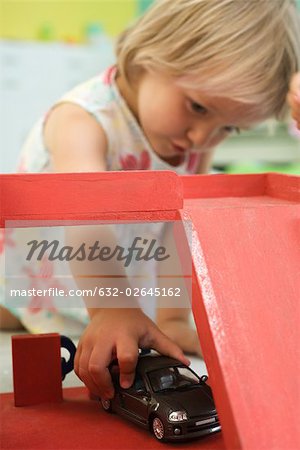 Little girl playing with toy car