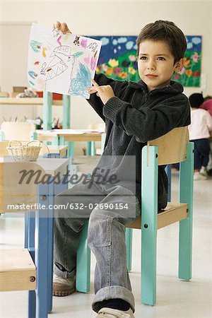 Boy showing drawing in class room