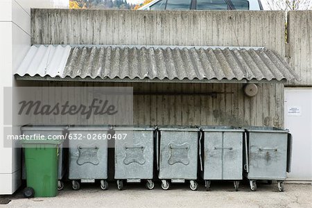 Trash bins lined up under awning