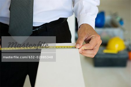 Well-dressed person measuring ledge width, close-up