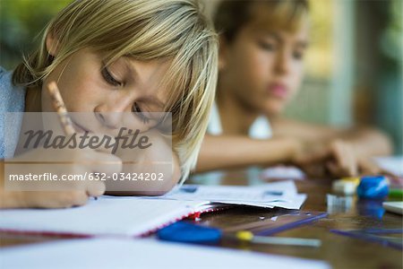 Junior high student resting head on arm while writing assignment