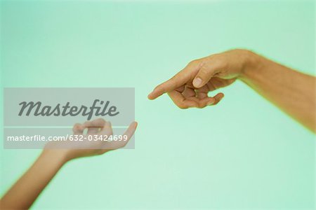 Two hands reaching toward each other with index fingers extended