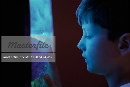 Boy watching TV, touching screen, profile