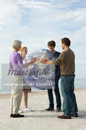 Ecology concept, four people placing hands on earth together