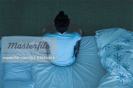 Man sitting on bed unable to sleep