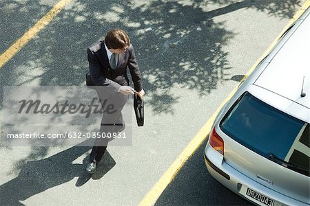 Man locking car doors using key remote as he walks away