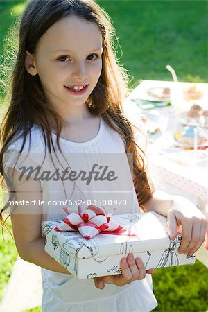 Girl at birthday party holding wrapped gift