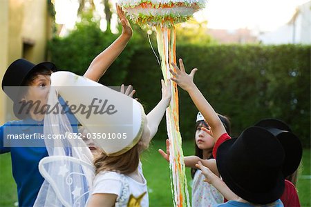 Children reaching to pull streamers attached to pull string pinata