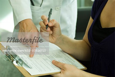 Doctor assisting patient with completing medical paperwork