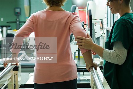 Patient undergoing rehabilitation walking exercises with assistance from physical therapist