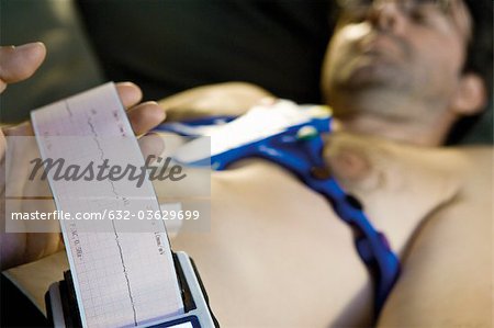 Doctor performing portable EKG (electrocardiogram) on patient