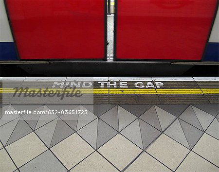 Mind the gap warning painted on the edge of the subway platform in the London Underground Mind the gap warning painted on the edge of the subway platform in the London Underground