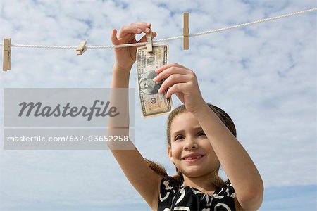 Girl hanging one million dollar bill on clothes-line