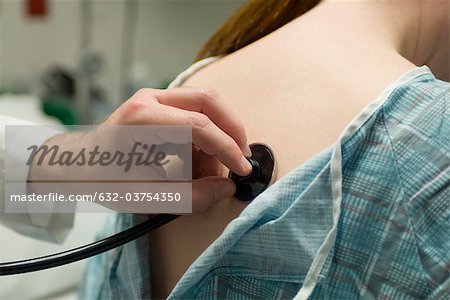 Doctor placing stethoscope on patient's back