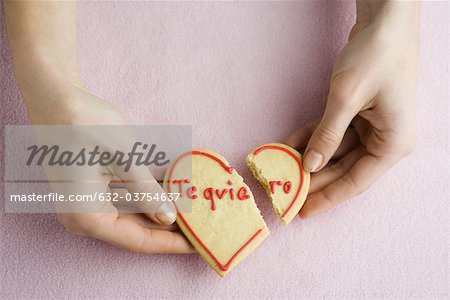 Holding broken heart-shaped cookie