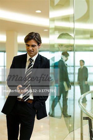 Businessman text messaging in lobby