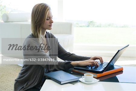Woman using laptop computer in living room