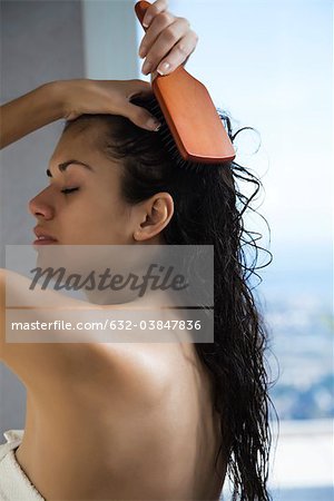Woman brushing wet hair after a shower
