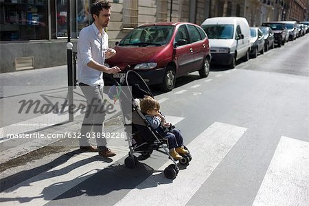 Father pushing toddler son in stroller