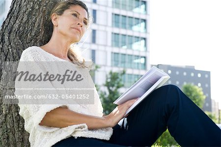 Woman with book looking away in thought