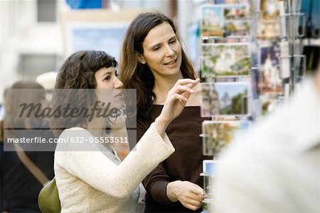 Female tourists looking at postcards