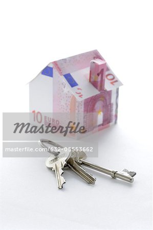 Bunch of keys and model house folded with Euro banknotes