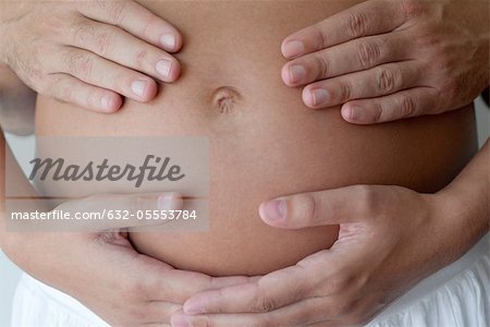 Couple's hands on woman's pregnant belly